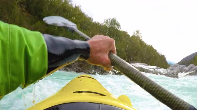 POV of a sportsman in his yellow kayak paddling down the rapids of an amazing blue river white water.