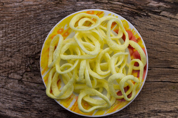 Plate with crispy snacks onion rings on wooden table
