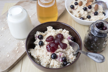 Delicious oatmeal porridge with berry and almonds for breakfast.