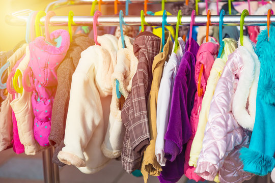 Rack of baby and children jackets displayed at outdoor hanger market for sale.