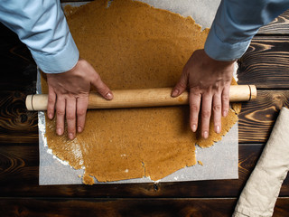 The recipe for making ginger biscuits. Rolls out the dough for ginger biscuits.