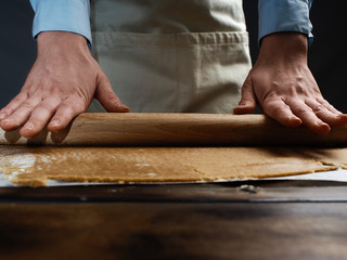 The recipe for making ginger biscuits. Rolls out the dough for ginger biscuits.
