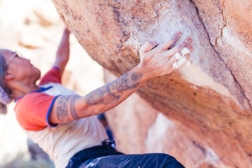 Closeup of hand of young asian woman rock climbing in the desert