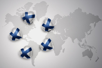 five hearts with national flag of finland on a world map background.