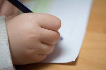 Kind malt und bastelt mit Buntstiften und Schere in Schule, Kindergarten und Hort