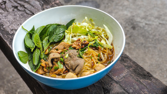 Boat noodles pork Thai food on wood close up