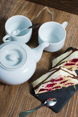 a teapot and a couple of cups with a cake on the table