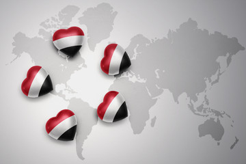 five hearts with national flag of yemen on a world map background.