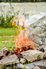 Camp fire. Bonfire diluted in the rocks against the background of the forest