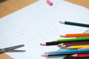 Kind malt und bastelt mit Buntstiften und Schere in Schule und Kindergarten
