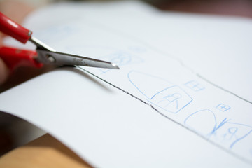 Kind malt und bastelt mit Buntstiften und Schere