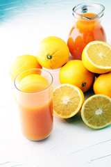 glass jar of fresh orange juice with fresh fruits on white table