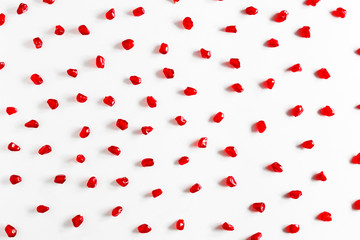 chaotically scattered pieces of pomegranate on a white backgroun