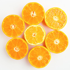a pattern of orange and yellow mandarins cut in half on a white 