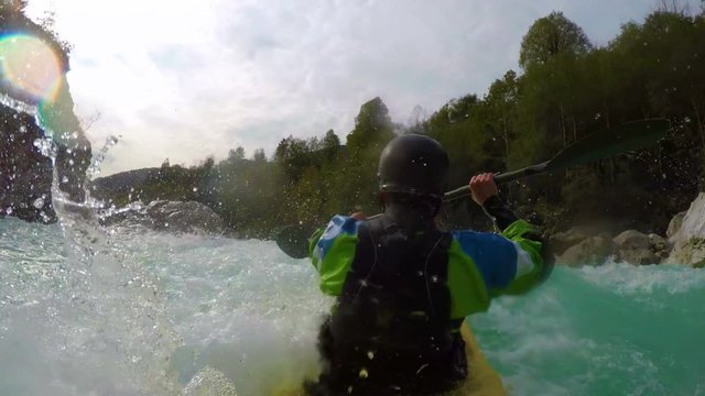 POV of kayaker in yellow kayak paddling down the rapids of an amazing blue river white water.
