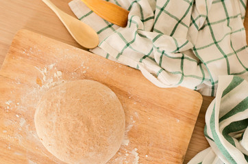 Fresch dough on the board with floar, chequered and striped  towel
