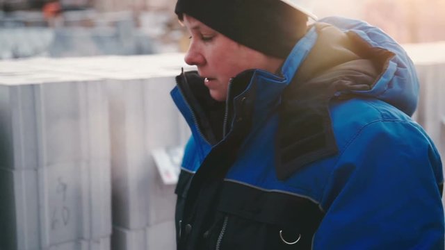 Woman engineer tells about stone building blocks close up
