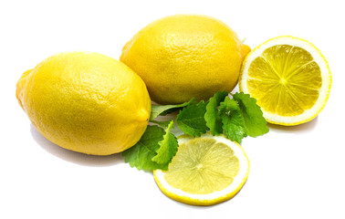 Two whole yellow lemons, cross section, slice and fresh green lemon balm leaves isolated on white background.