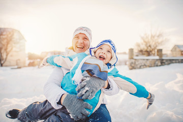 Obraz premium Happy family mother and child sun having fun, playing at winter park