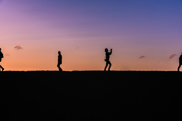 Fototapeta premium People silhouette on a top of a hill
