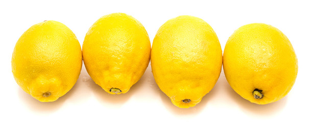 Group of four whole yellow lemons in row isolated on white background .