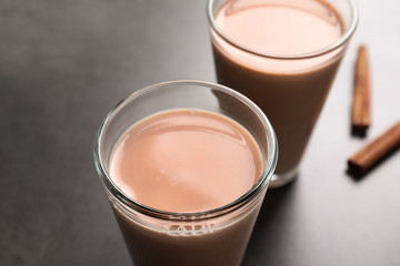Glasses with delicious cocoa drink on grey background