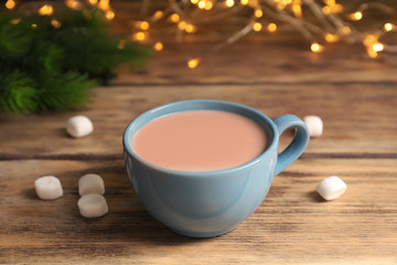 Cup with delicious cocoa drink on wooden background