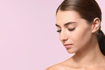 Naklejka premium Young woman with eyelash extensions on color background