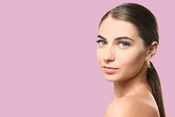 Obraz premium Young woman with eyelash extensions on color background