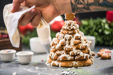 Decorating gingerbread Christmas sweet tree with frosting