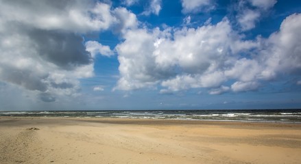 Fototapeta na wymiar Dutch beach on a clear day with some clouds