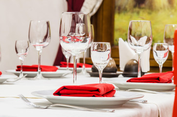 Served table with glasses, cutlery and napkins