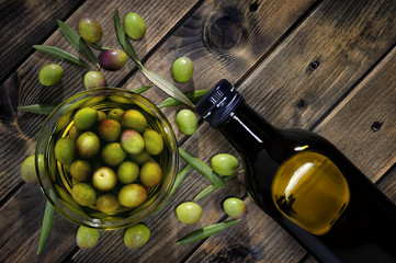 Freshly harvested fresh olives photographed on an antique wooden table.