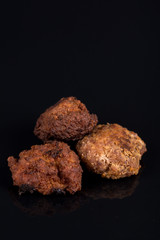 Meatballs isolated above black background with reflections and copy space