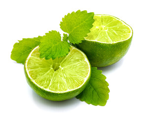Two lime halves and fresh green lemon balm leaves isolated on white background.