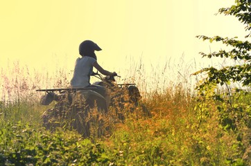 Young people driving a quad bike on a sunny day