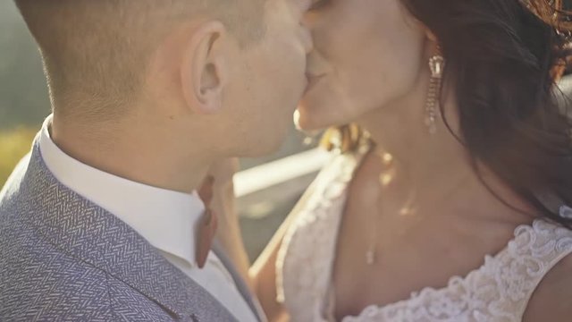 Happy bridal couple kissing in sunshine