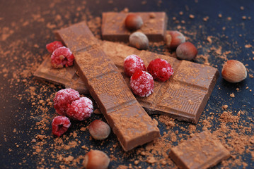 Crushed Dark Chocolates, Heselnuts and Strapberry, dark background. Sweet dessert