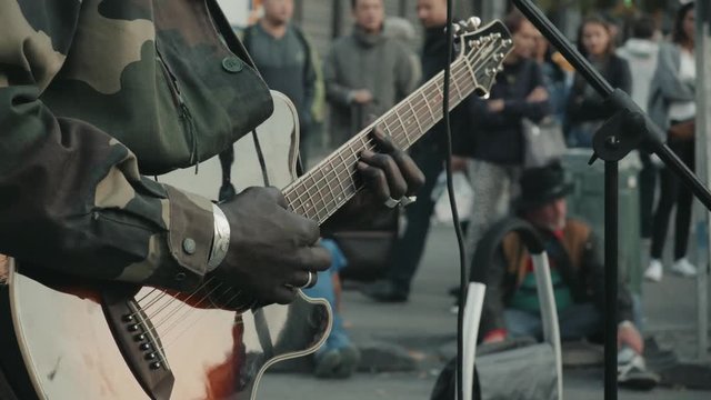Close-up Of Guitarist Male Hand And Fingers Who Touches String On The Black Acoustic Six String Guitar. Street Musical Band Play Latin Music