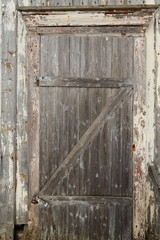 Closed batten door of ruined-abandoned-paint faded wooden hut. Vareid-Flakstadoya-Lofoten-Norway. 0538