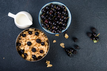 Obraz na płótnie Canvas Cornflakes cereals with berries on dark background, flat lay