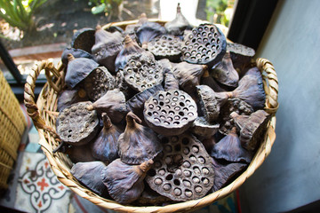 Dry old  lotus pods with seeds and empty holes close up for background in wicker basket. Seed stem. Amazing plant design.Partial focus