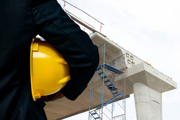 Engineer with bridge under construction background