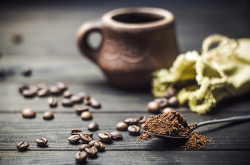 A cup of coffee beans and a bag on the old table. Breakfast.