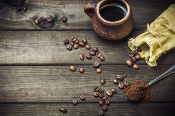 A cup of coffee beans and a bag on the old table. Breakfast.