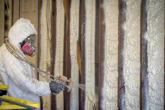 Worker Spraying Closed Cell Spray Foam Insulation On A Home That Was Flooded By Hurricane Harvey