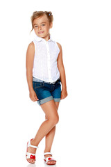 A little girl in shorts and a white shirt.
