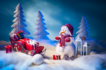 Obraz premium New Year. The snowman unloads gifts for the new year. White snowman surrounded by Christmas trees.