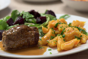 Healthy dish - roast beef roulade, carrot dumplings and rucola salad with red beetroot