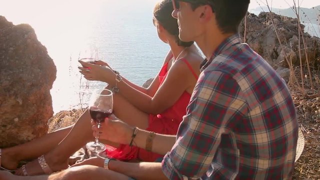 Romantic picnic of loving couple with seaside and mountain view at sunset